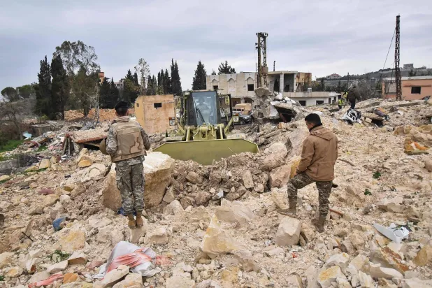 جنود لبنانيون يشرفون على فتح الطرقات في بلدة رب تلاتين بجنوب لبنان (أ.ف.ب)