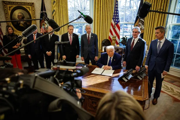 الرئيس الأميركي دونالد ترمب يتحدث إلى وسائل الإعلام أثناء توقيعه على الأوامر التنفيذية في المكتب البيضاوي بالبيت الأبيض (إ.ب.أ)