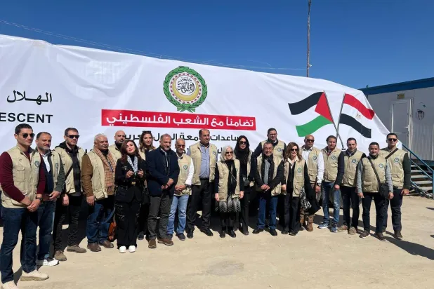 وفد الجامعة العربية أمام شاحنة مساعدات قبل عبورها إلى قطاع غزة (الجامعة العربية) 