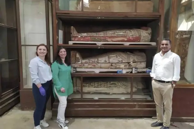 باحثون مع توابيت بداخلها مومياوات