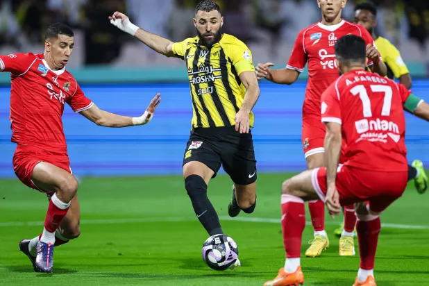 بنزيمة محاصرا بلاعبي الوحدة خلال المباراة (نادي الاتحاد)