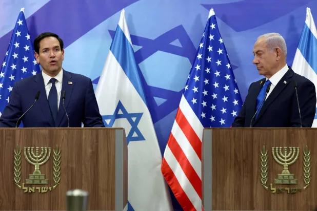 نتنياهو يستمع إلى روبيو خلال مؤتمر صحافي مشترك في تل أبيب اليوم (أ.ف.ب)