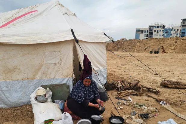 أنعام عبد المالك (أم عدي) أمام خيمتها في مخيم الشاطئ (الشرق الأوسط)