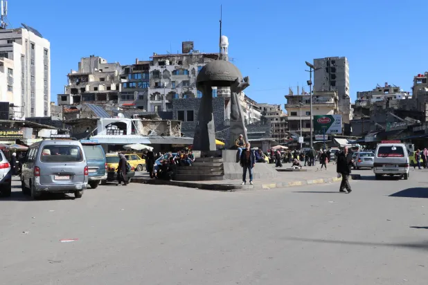 دوار الساعة القديمة ومدخل سوق الحميدية الشهير في حمص وتظهر أبنية مدمرة من معارك فترة الحرب (الشرق الأوسط)