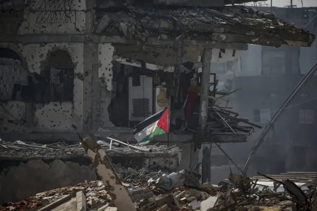 Kuzey Gazze Şeridi'ndeki Cibaliye mülteci kampında yıkılan binaların enkazı arasında Filistinli bir aile için inşa edilen sığınağın yanında dalgalanan Filistin bayrağı, 17 Şubat 2025 (AFP