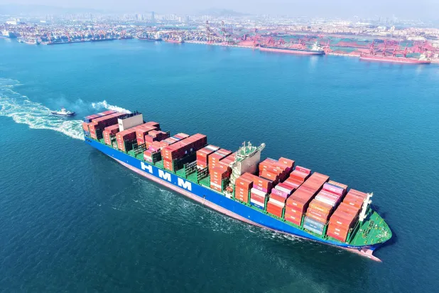 سفينة شحن عملاقة تحمل حاويات تبحر من ميناء قوينغداو شرق الصين (أ.ف.ب)