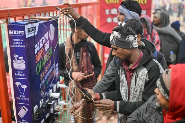 أشخاص يشحنون هواتفهم الجوالة في الهند (أ.ف.ب)