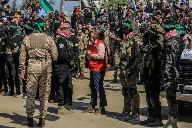 صورة ملتقطة في 15 فبراير 2025، في خان يونس بقطاع غزة تظهر مقاتلين لحركة «الجهاد الإسلامي» و«كتائب عز الدين القسام»، الجناح العسكري لحركة «حماس»، مع ممثلة الصليب الأحمر أثناء تسليم ثلاث رهائن إسرائيليين (د.ب.أ)