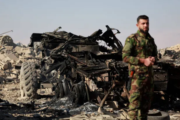 مقاتل تابع للقيادة الجديدة في سوريا يتفقد الدمار في موقع عسكري في أعقاب غارة إسرائيلية في دمشق، سوريا، 14 ديسمبر 2024 (رويترز)