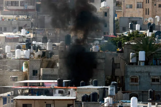 تصاعد الدخان خلال مداهمة في مخيم طولكرم للاجئين الفلسطينيين ضمن عملية عسكرية إسرائيلية مستمرة في الضفة الغربية المحتلة (أ.ف.ب)