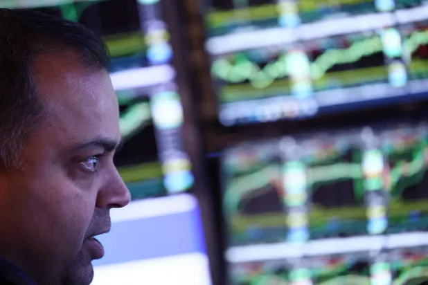 متداول في بورصة نيويورك يراقب تحرك أسعار الأسهم والسندات (رويترز)