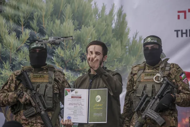 من مراسم تسليم الرهائن الإسرائيليين للصليب الأحمر في مخيم النصيرات بوسط قطاع غزة السبت (إ.ب.أ)