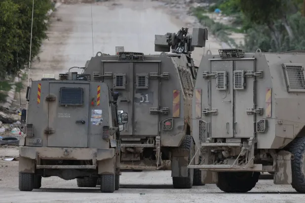 آليات عسكرية إسرائيلية تقطع الطريق خلال عملية عسكرية في مخيم طولكرم بالضفة الغربية (إ.ب.أ)