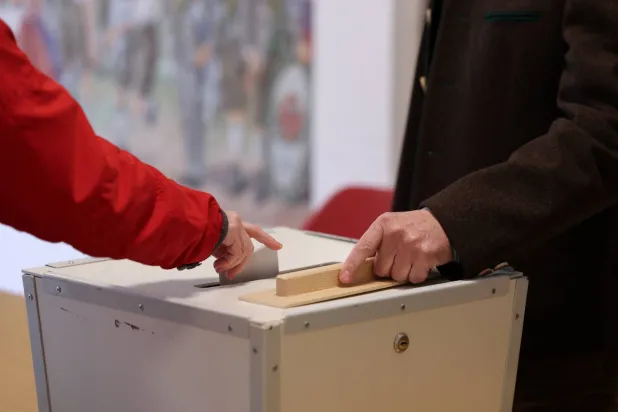 شخص يدلي بصوته خلال الانتخابات العامة في ميسباخ بألمانيا (رويترز)