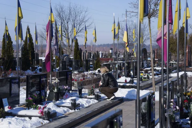 امرأة تقف أمام قبر قريب لها خلال فعالية لتذكر قتلى الحرب الأوكرانية في منطقة بوشا قرب كييف الاثنين (أ.ب)