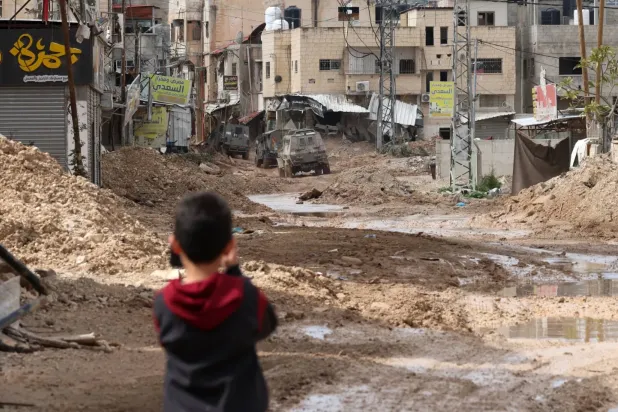 Filistinli bir çocuk dün İsrail işgal güçlerinin Cenin kampına saldırısını izliyor (EPA)