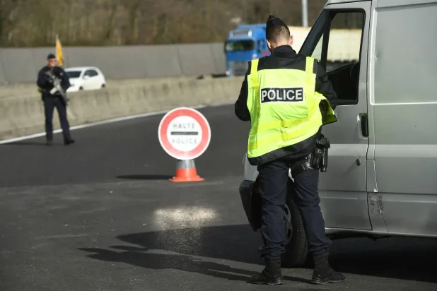 شرطي يدقق بمركبة أثناء عملية أمنية في جنوب غربي فرنسا (أ.ف.ب)