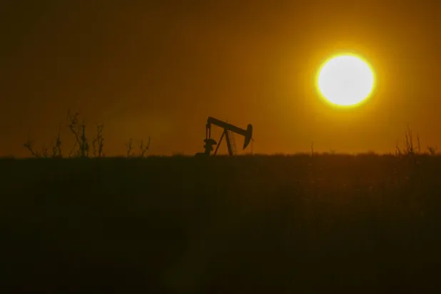 الشمس تشرق بينما تعمل مضخة النفط في هوبز بنيومكسيكو (أ.ب)