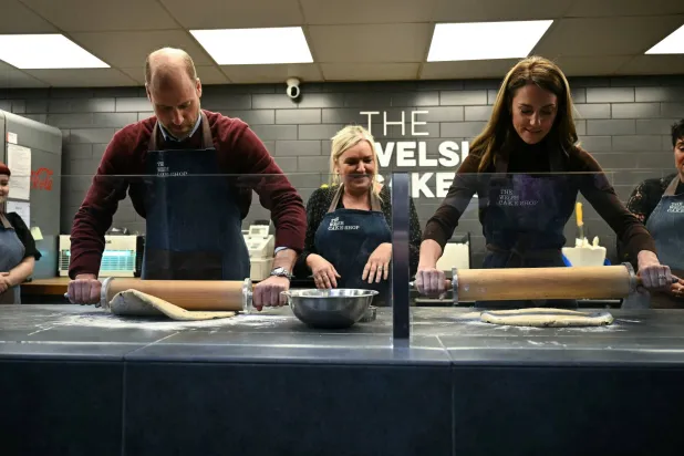 الأمير البريطاني ويليام وزوجته كيت يتفاعلان أثناء صنع الكعك الويلزي (رويترز)