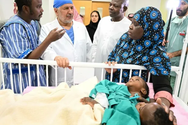 الدكتور عبد الله الربيعة في حديث مع والدي الطفلين قبل العملية (واس)