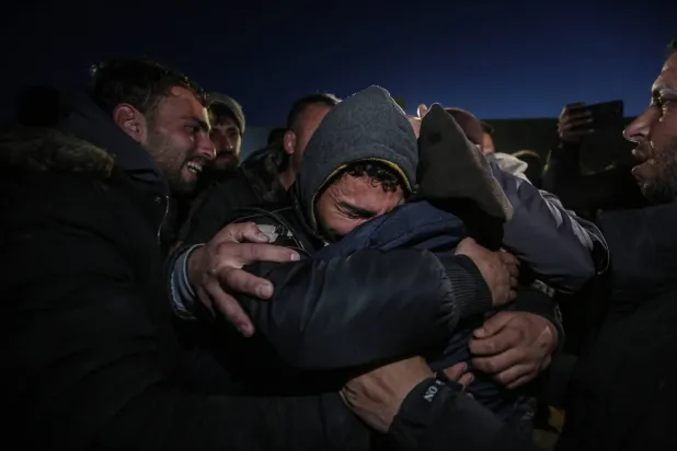 معتقلون فلسطينيون مفرج عنهم يعانقون ذويهم لدى وصولهم إلى قطاع غزة مساء الأربعاء (د.ب.أ)