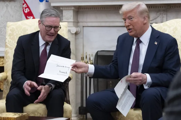 الرئيس الأميركي دونالد ترمب (يمين) ورئيس الوزراء البريطاني كير ستارمر يعرضان رسالة من الملك البريطاني تشارلز (إ.ب.أ)