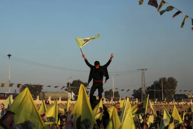 أكراد يرفعون أعلاماً بعد إذاعة رسالة أوجلان لإلقاء السلاح في الحسكة الخميس (رويترز)
