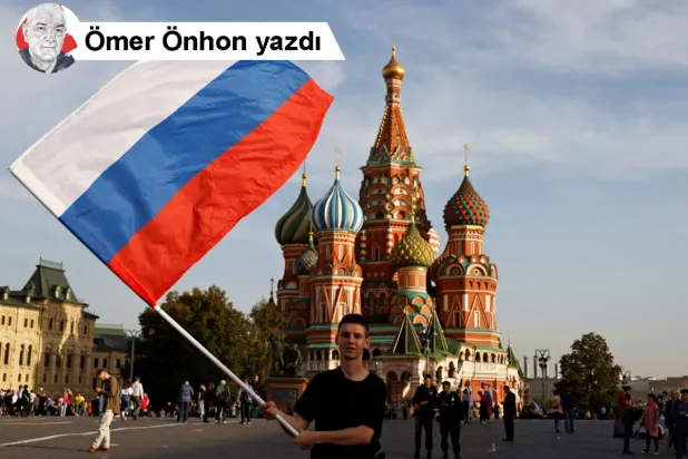 Bir genç, Rusya'nın Ukrayna'nın dört bölgesini ilhak etmesinin birinci yıl dönümünü anma yürüyüşü öncesinde Kızıl Meydan'da Rus bayrağı sallıyor, Moskova, Rusya, 29 Eylül 2023