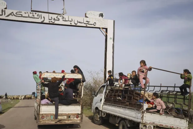 نازحون في الشاحنات أثناء إجلائهم بسبب مخاوف من توغلات الجيش الإسرائيلي في أعقاب هجوم مسيّرة على قرية كويا جنوب غربي سوريا الثلاثاء (أ.ب)