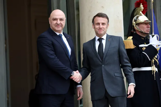 الرئيس الفرنسي إيمانويل ماكرون (يمين) يصافح الرئيس اللبناني جوزيف عون بقصر الإليزيه في باريس (رويترز)