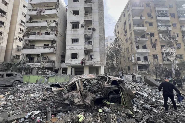  A man walks next to a destroyed car and damaged buildings at the site that was hit by an Israeli airstrike in Dahiyeh, in the southern suburb of Beirut, Lebanon, Friday March 28, 2025.(AP) 