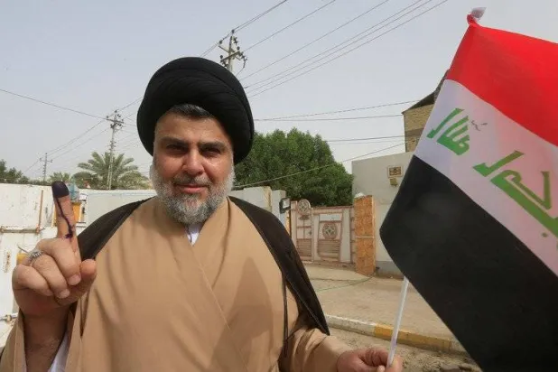 Shiite cleric Moqtada al-Sadr shows his ink-stained finger after casting his vote at a polling station in Najaf, Iraq, in May 2018. (Reuters)