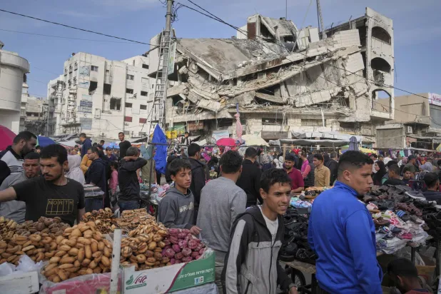 فلسطينيون يشترون الطعام قبل عيد الفطر في سوق الزاوية بمدينة غزة يوم الجمعة (أ.ب)