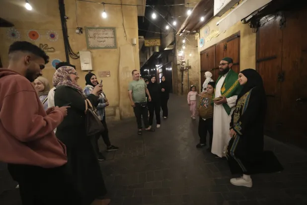 أطفال يلتقطون صوراً تذكارية الى جانب "المسحراتي" في مدينة صيدا بجنوب لبنان (أ ب)