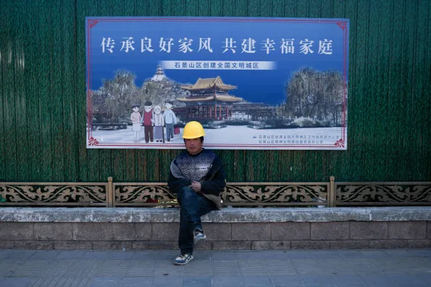 عامل يستريح في موقع إنشاءات بالعاصمة الصينية بكين (أ.ف.ب)