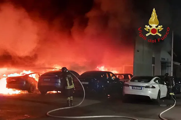 رجال إطفاء يعملون على إخماد حريق بوكالة سيارات «تسلا» في روما (أ.ف.ب)