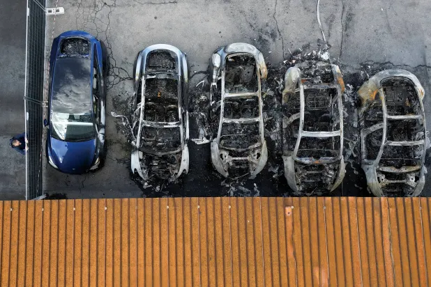 صورة التقطتها طائرة مسيّرة تُظهر مركبات تسلا متفحمة بعد حريق في وكالة لتسلا أدى إلى تدمير المركبات في روما 31 مارس 2025 (رويترز)