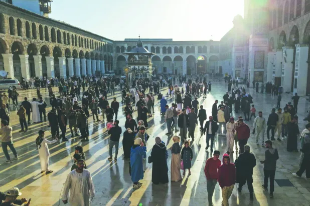 صورة جوية تظهر الزوَّار يتجمعون في ساحة المسجد الأموي بدمشق صباح الاثنين أول أيام عيد الفطر (أ.ف.ب)