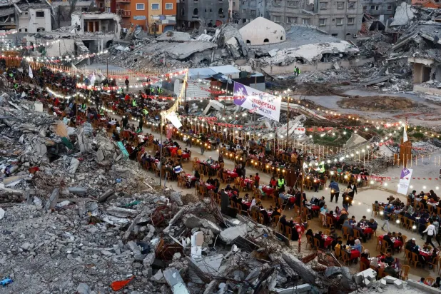 Dün Gazze Şeridi'nin güneyindeki Refah'ta Ramazan'ın ilk gününde yıkıntıların ortasında kurulan iftar sofrası (Reuters)