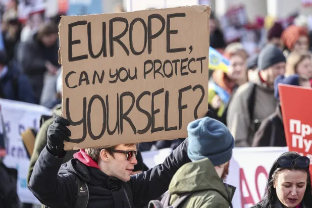 محتج يحمل لافتة كتب عليها «أوروبا... هل تستطيعين حماية نفسك؟» خلال مظاهرة مناهضة لبوتين في برلين (أ.ب)