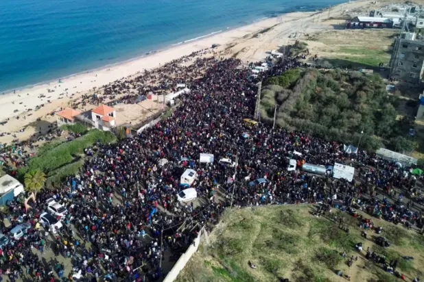 نازحون من غزة يتجمعون في منطقة النصيرات للعودة إلى منازلهم في الجزء الشمالي من قطاع غزة (أ.ف.ب)