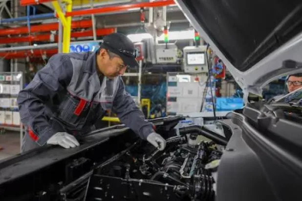يعمل الموظفون على خط التجميع في مصنع موسكوفيتش للسيارات بموسكو (رويترز)