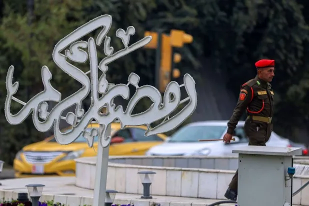 An Iraqi soldier walks past a sign that reads "Ramadan Kareem" in the Karrada district of the capital Baghdad on March 5, 2025, during the Muslim holy fasting month of Ramadan. (AFP)