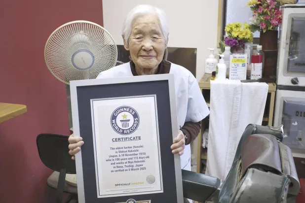 Shitsui Hakoishi, 108, poses for a photo with a Guinness World Records certificate recognizing her as the world's oldest female barber, at her shop in Nakagawa in Tochigi Prefecture, eastern Japan, on Wednesday March 5, 2025. (Kyodo Photo via AP)