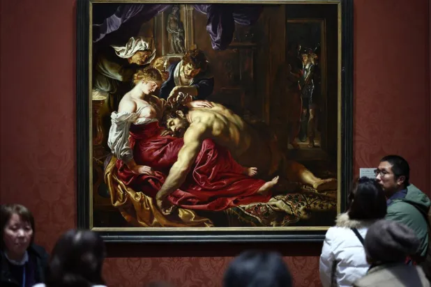 Members of the public study 'Samson and Delilah', a 1610 oil painting attributed to Flemish painter Peter Paul Rubens in the National Gallery in London. HENRY NICHOLLS / AFP
