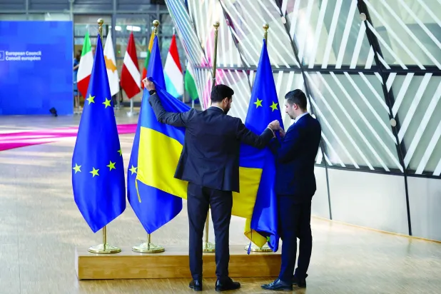 يستبدل الموظفون عَلم أوكرانيا بعَلم الاتحاد الأوروبي في يوم القمة الخاصة لقادة الاتحاد الأوروبي (رويترز)