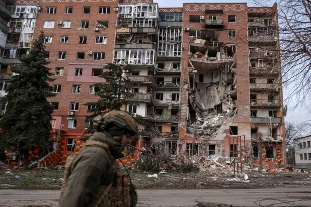 A Ukrainian serviceman passes by a residential building damaged by Russian military strikes, amid Russia's attack on Ukraine, in the frontline town of Pokrovsk in Donetsk region, Ukraine March 6, 2025. REUTERS/Inna Varenytsia     