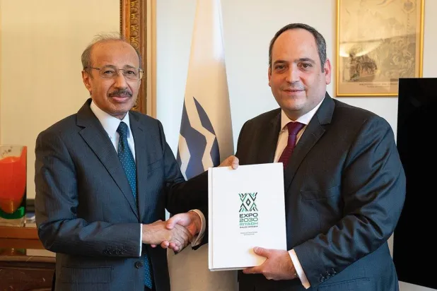 ديمتري كيركنتزس أمين عام المكتب الدولي للمعارض يتسلّم الملف من فهد الرويلي السفير السعودي لدى فرنسا (الهيئة الملكية للرياض)