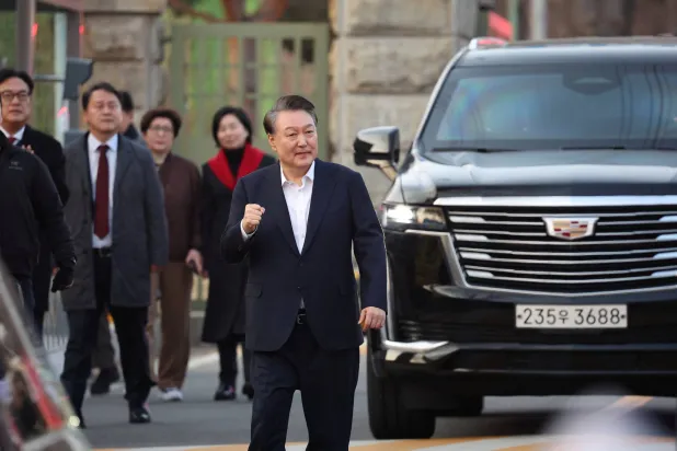 الرئيس الكوري الجنوبي المعزول يسير في الشارع عقب إطلاق سراحه من مركز احتجاز في سيول (رويترز)