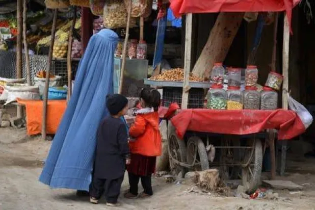 سيدة أفغانية بصحبة أطفالها في إحدى أسواق كابل بأفغانستان شهر مارس 2025 (أ.ف.ب)